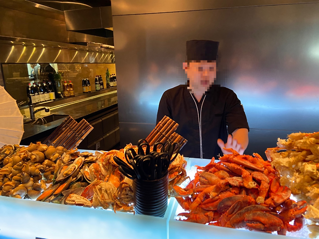 서울 여의도 콘래드 서울 뷔페 ‘제스트’의 해산물 코너 ‘오션’에서 셰프가 요리를 설명하는모습. <박홍주 기자>