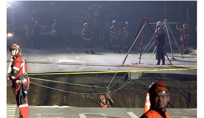 3월 24일 대형 땅 꺼짐 사고가 발생한 서울 강동구 대명초등학교 인근 사거리에서 소방대원이 내부 구조 작업에 나서고 있다. (연합뉴스)