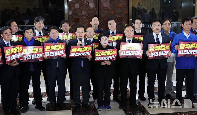 [서울=뉴시스] 조성우 기자 = 이건태(앞줄 왼쪽 네 번째) 더불어민주당 의원 등 초선의원 모임인 '더민초' 의원들이 28일 오후 서울 여의도 국회 로텐더홀에서 열린 비상시국대응 긴급기자회견에서 윤석열 대통령 파면을 촉구하는 피케팅을 하고 있다. 2025.03.28. xconfind@newsis.com