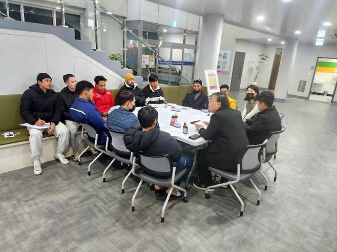 김탁 대불복합문화센터장이 외국인 근로자들과 축구 리그 팀 편성 회의를 하고 있다. 이서희 기자