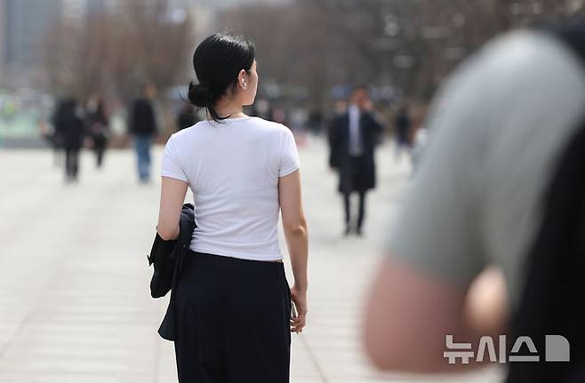 [서울=뉴시스] 김진아 기자 = 낮 기온이 20도 이상 오르는등 봄 날씨가 이어지고 있는 26일 서울 종로구 광화문광장에서 반팔은 입은 시민이 걸어가고 있다. 2025.03.26. bluesoda@newsis.com