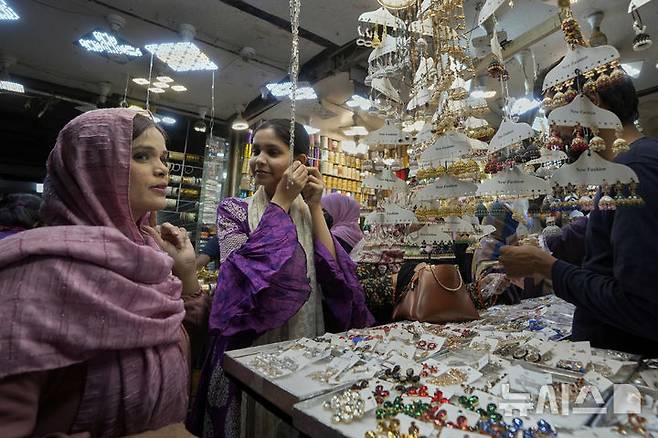 [카라치=AP/뉴시스] 23일(현지 시간) 파키스탄 카라치에서 무슬림 여성들이 라마단 성월의 종료를 축하하는 이드 알피트르 축제를 준비하기 위해 장을 보고 있다. 이드 알피트르는 라마단이 끝난 것을 축하하는 '단식 종료' 축제로 3일간 이어진다. 2025.03.24.