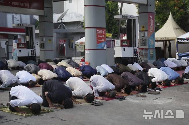 [자카르타=AP/뉴시스] 31일(현지 시간) 인도네시아 자카르타의 한 주유소에서 무슬림들이 라마단 성월의 끝을 알리는 이드 알피트르 기도를 올리고 있다. 2025.03.31.