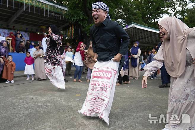 [케손시티=AP/뉴시스] 31일(현지 시간) 필리핀 케손시티의 한 공원에서 라마단을 마친 무슬림들이 마대자루 경기를 하면서 이드 알피트르 축제를 즐기고 있다. 2025.03.31.