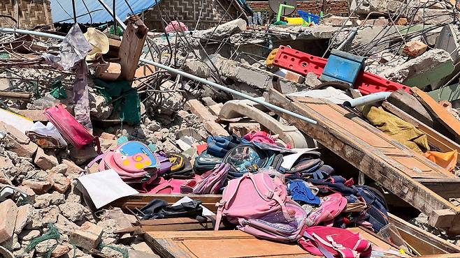 만달레이 카욱세 지역의 유치원 건물이 무너진 현장에 알록달록한 어린이들의 책가방이 널브러져 있다