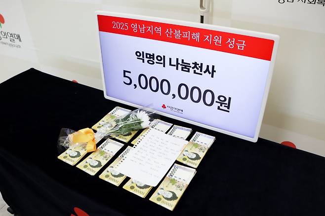 2017년부터 어려운 이웃을 위해 익명으로 성금을 보내 ‘경남 기부 천사’로 불리는 남성이 1일 오전 경남사회복지공동모금회 사무국 모금함 뒤에 두고 간 산불 성금 500만 원과 손 편지, 그리고 국화꽃 한송이. 이 남성이 현재까지 안타까운 사고가 발생하거나 연말에 기부한 누적액이 6억9000여만 원에 달한다. 경남사회복지공동모금회 제공