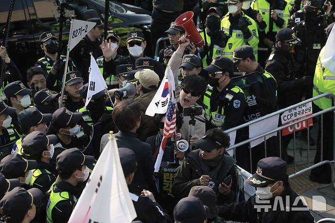 [서울=뉴시스] 정병혁 기자 = 윤석열 대통령 탄핵심판 선고일이 결정된 1일 서울 종로구 헌법재판소 인근에서 경찰이 시위 중이던 윤 대통령 탄핵 반대 참가자들을 헌법재판소 100m 밖으로 밀어내고 있다.2025.04.01. jhope@newsis.com