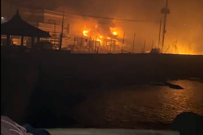 불타는 영덕 축산면 경정3리 (영덕=연합뉴스) 경북산불이 확산한 지난달 25일과 26일 사이 영덕군 축산면 경정3리 주택과 상가가 불에 타고 있다.
당시 주민들은 중간에 보이는 방파제의 오른쪽 맨 끝에 가서 대피하고 있었다. [전대헌씨 제공 동영상 캡처. 재판매 및 DB 금지]