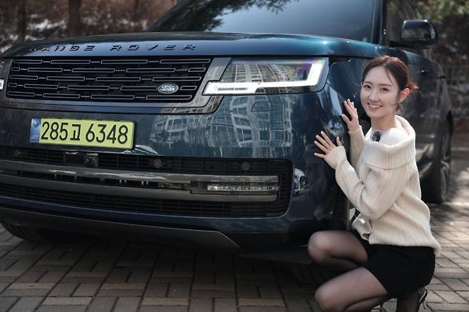 글로벌 이코노믹 이정경 앵커가 레인지로버 SWB P550e 옆에서 포즈를 취하고 있다.