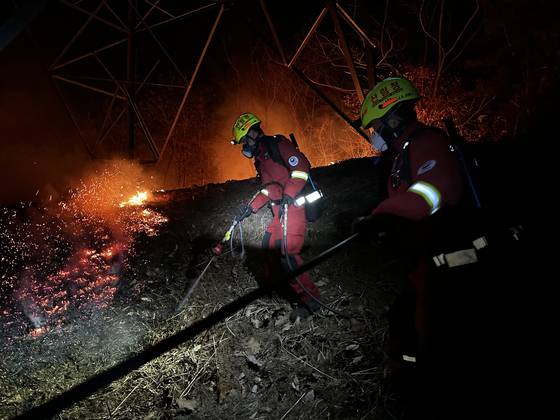 산림청 공중진화대와 산불재난특수진화대가 지난달 26일 오후부터 27일 새벽 사이 경남 산청군 시천면 동당리 일대에서 지리산과 민가를 지키기 위해 사투를 벌이고 있다. 고성능 산불진화차와 연결된 호스로 불길을 잡고 있는 모습. 사진 산림청