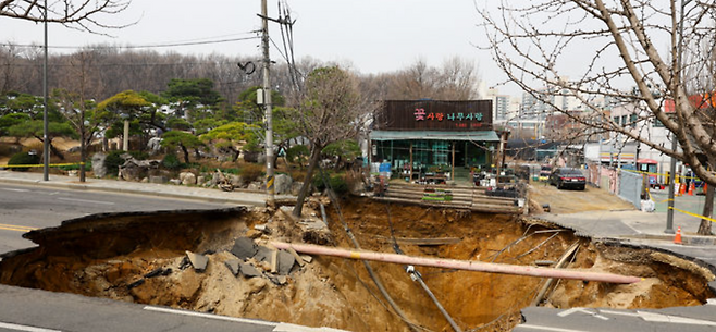 지난달 25일 서울 강동구 명일초등학교 인근 도로에서 전날 발생한 싱크홀(땅 꺼짐) 사고 현장 모습. 뉴시스