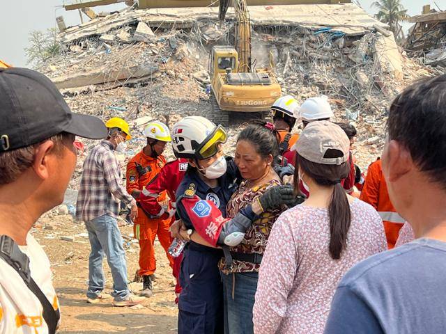 2일 오전 미얀마 만달레이의 지진으로 무너진 아파트에서 시신 수습 작업이 이뤄지고 있다. 가족 시신이 발견돼 오열하는 미얀마 여성을 구조대원이 끌어안고 위로하고 있다. 만달레이(미얀마)=허경주 특파원