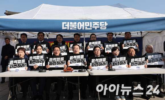 이재명 더불어민주당 대표와 박찬대 원내대표가 지난달 19일 서울 종로구 경복궁역 부근 광화문 민주당 천막농성장에서 열린 현장 최고위원회의에서 "윤석열을 파면하라!"라고 적힌 피켓을 들고 구호를 외치고 있다. [사진=국회사진취재단]