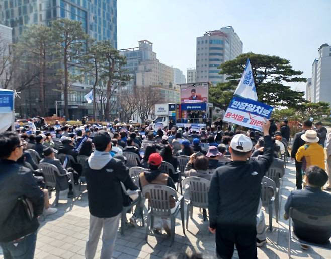 4일 오전 11시께 인천시청 앞 광장에서 민주당 당원과 시민이 대형 TV 화면으로 생중계되는 헌법재판소의 윤석열 대통령 탄핵 선고 과정을 지켜보고 있다. (사진 = 이종일 기자)