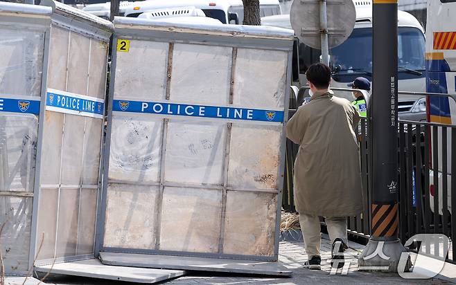 윤석열 대통령의 탄핵 심판이 인용된 4일 서울 용산구 한남동 대통령 관저 앞에서 한 시민이 경찰이 설치한 가벽 사이로 통행하고 있다. 이날 헌법재판소는 재판관 전원 일치 의견으로 윤 대통령 파면을 결정했다. 2025.4.4/뉴스1 ⓒ News1 김성진 기자