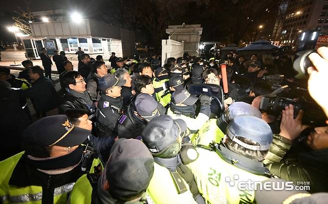 윤석열 대통령이 3일 밤 비상계엄령을 선포한 가운데 폐쇄가 결정된 국회 정문에서 경찰과 국회 관계자들이 대치하고 있다. 김민수기자 mskim@etnews.com
