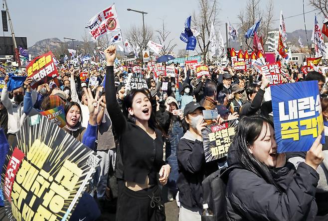 Ralliers cheer upon hearing the Constitutional Court's ruling that upheld the impeachment of now-former President Yoon Suk Yeol near Anguk Station in central Seoul, on Apr. 4. [PARK SANG-MOON]