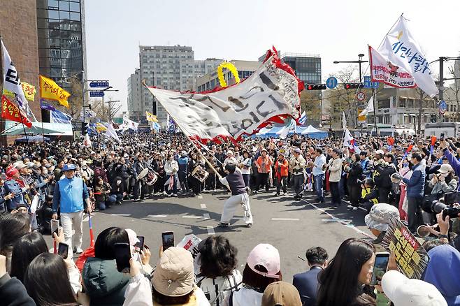 A man wearing traditional Korean clothing waves a flag in the middle of a anti-Yoon Suk Yeol protest near Anguk Station in central Seoul, on Apr. 4. [PARK SANG-MOON]