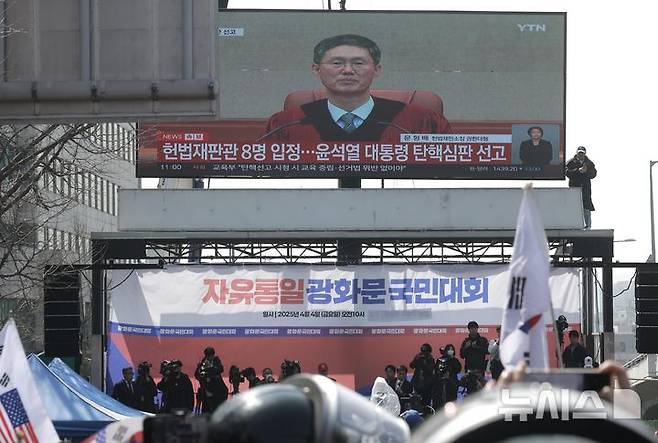 [서울=뉴시스] 정병혁 기자 = 윤석열 대통령 탄핵 심판 선고일인 4일 서울 용산구 한남동 관저 앞에서 열린 탄핵 반대 집회에서 참가자들이 헌재 선고 생중계를 보고 있다. 2025.04.04. jhope@newsis.com
