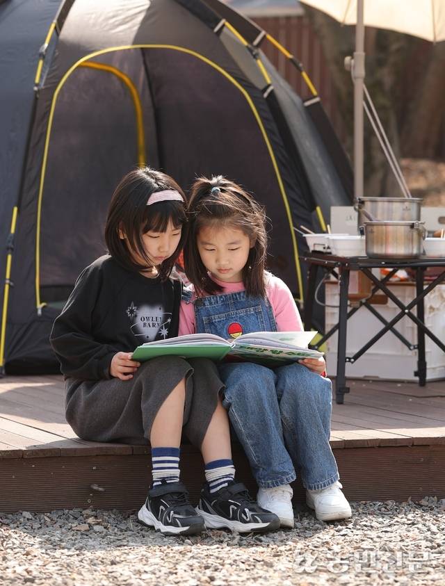 캠핑장에서 책을 보고 있는 아이들. 본관에 금곡작은도서관이 있어 독서를 즐기기 좋다.