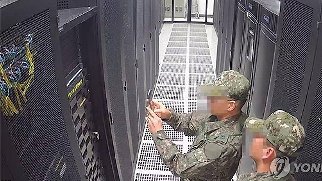 [국회 행정안전위원회는 지난 3일 계엄령 선포 당시 선거관리위원회에 투입된 계엄군이 선관위 시스템 서버를 촬영하는 장면이 담긴 CCTV를 6일 공개했다. (행정안전위원회 제공=연합뉴스)]