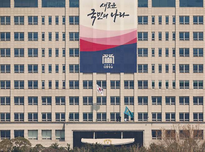 4일 헌법재판소가 윤석열 대통령 파면을 선고한 뒤 서울 용산구 대통령실에서 관계자들이 봉황기(오른쪽)를 내리고 있다. 연합뉴스