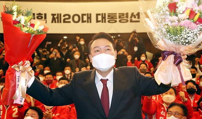 윤석열 전 대통령 당선인이 2022년 3월10일 새벽 서울 여의도 국회도서관에 마련된 '국민의힘 제20대 대통령선거 개표상황실'에서 꽃다발을 들고 포즈를 취하고 있다. ⓒ연합뉴스