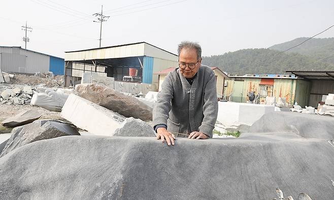 고석산 석장이 작업장에서 석불 작업에 사용할 재료를 선택하고 있다.