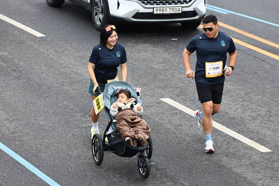 6일 오전 8시 경기도 고양시 고양종합운동장 일대에서 열린 ‘2025 고양특례시 하프마라톤’에서 한 여성 참가자가 유모차를 밀며 달리고 있다. 김종호 기자