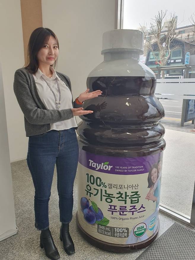 김주영 과장이 유기농착즙 푸룬주스 모형물 앞에서 포즈를 취하고 있다. 윤현주 기자