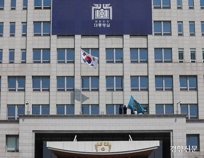 지난 4일 서울 용산구 대통령실에 걸려있던 봉황기(왼쪽)가 헌법재판소의 윤석열 대통령 탄핵 인용 이후 대통령실 관계자들에 의해 내려지고 있다. 대통령실사진기자단