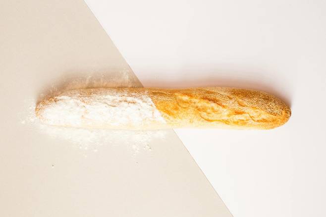 바케트 빵위에 왼쪽 절반에는 밀가루가 위에 부려져 있음