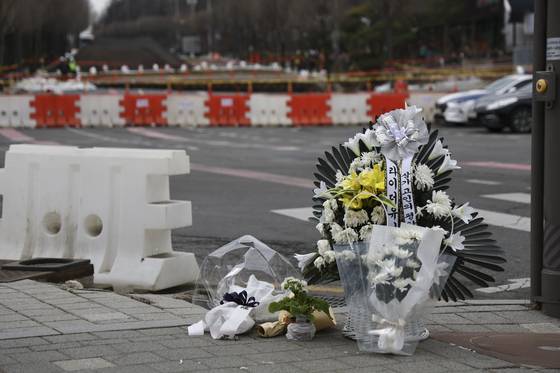 서울 강동구 명일동 싱크홀 현장에 이번 사고로 숨진 배달 노동자 박모씨를 추모하는 꽃이 놓여 있다. 〈출처 : 연합뉴스〉