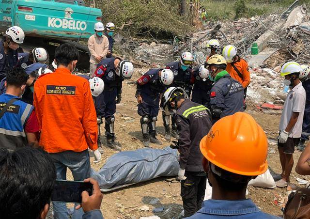 지난 2일 지진 피해를 입은 미얀마 중북부 만달레이의 아파트 붕괴 현장에서 구조 대원들이 희생자를 수습한 뒤 목례로 예를 갖추고 있다. 만달레이=허경주 특파원