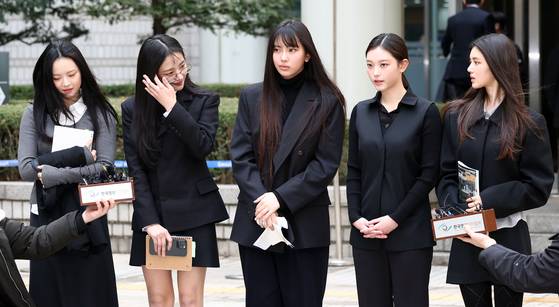 걸그룹 뉴진스(NJZ)가 지난달 7일 서울 서초구 서울중앙지방법원에서 열린 '기획사 지위보전 및 광고계약 체결 등 금지' 가처분 신청의 심문기일을 마친 뒤 법원 청사를 나서며 취재진 질문에 답하고 있다.   왼쪽부터 하니, 민지, 혜인, 해린, 다니엘. 연합뉴스