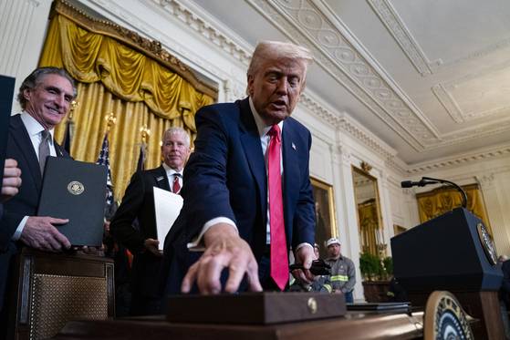 U.S. President Donald Trump hands out pens after signing executive orders during a ceremony at the White House in Washington on April 8. [UPI/YONHAP]