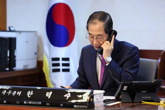 Acting President and Prime Minister Han Duck-soo talks on the phone with U.S. President Donald Trump at the Seoul Government Complex in Jongno District, central Seoul, on April 8. [YONHAP]