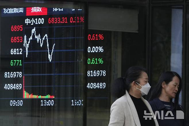 [베이징=AP/뉴시스] 중국 정부 기관, 국부펀드들이 중국 주식시장 폭락을 막기 위해 총력전을 벌이는 가운데 증시 방어에 구원투수로 나서는 국유기업들도 늘어나고 있다. 사진은 베이징 도심에서 행인들이 주식시장 시황을 보여주는 전광판 앞을 지나가고 있다. 2025.04.09