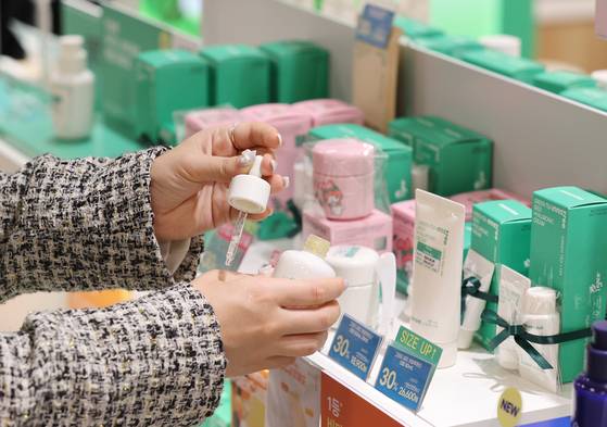 A shopper tests a skincare product at a shop in Seoul on Jan. 6. [YONHAP]