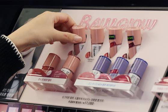 A shopper looks at lip tint products at a store in Seoul on Dec. 2, 2024. [YONHAP]