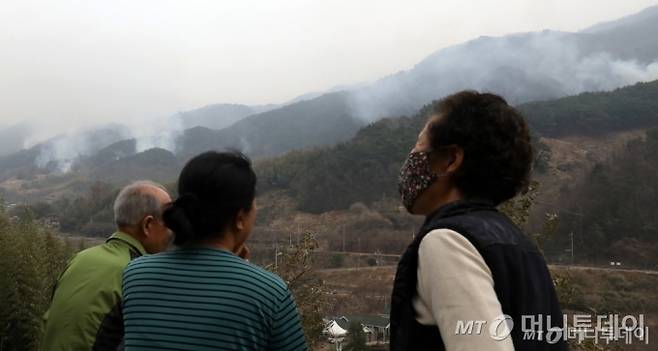 (산청=뉴스1) 윤일지 기자 = 경남 산청·하동 산불 일주일째인 27일 오후 주민들이 지리산과 인접한 산청군 시천면 동당마을 위로 피어오르는 산불 연기를 지켜보고 있다.   산청에는 오후부터 5mm 내외의 적은 비가 예보됐지만 현재 비는 내리지 않고 있다. 2025.3.27/뉴스1  Copyright (C) 뉴스1. All rights reserved. 무단 전재 및 재배포,  AI학습 이용 금지. /사진=(산청=뉴스1) 윤일지 기자