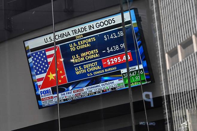 9일(현지시간) 미국 뉴욕 타임스퀘어의 나스닥 마켓사이트에서 미국과 중국 간 무역에 관한 뉴스가 텔레비전 화면에 나오고 있다.  [AFP]