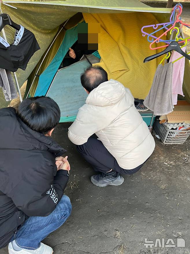 [성남=뉴시스] 성남시노숙인종합지원센터 종사자들이 모란역 인근에 텐트를 치고 생활 중인 노숙인을 지원하기 위해 대화를 시도 중이다 (사진=성남시 제공) 2025.04.10.photo@newsis.com