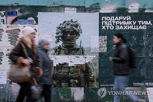 우크라이나 키이우에서 군인 포스터 앞을 지나는 시민들 [EPA 연합뉴스 자료사진. 재판매 및 DB 금지]