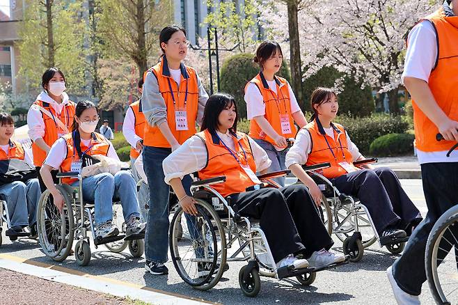 11일 오후 목원대 교정에서 사회복지학과 학생과 교직원이 휠체어 등을 타고 장애체험 가두행진을 벌이고 있다. 목원대 제공