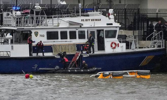 10일 미국 뉴욕 로어 맨해튼 인근 허드슨 강에서 발생한 헬리콥터 추락 사고 현장에서 구조대원들과 응급요원들이 작업하고 있다. 로이터연합뉴스