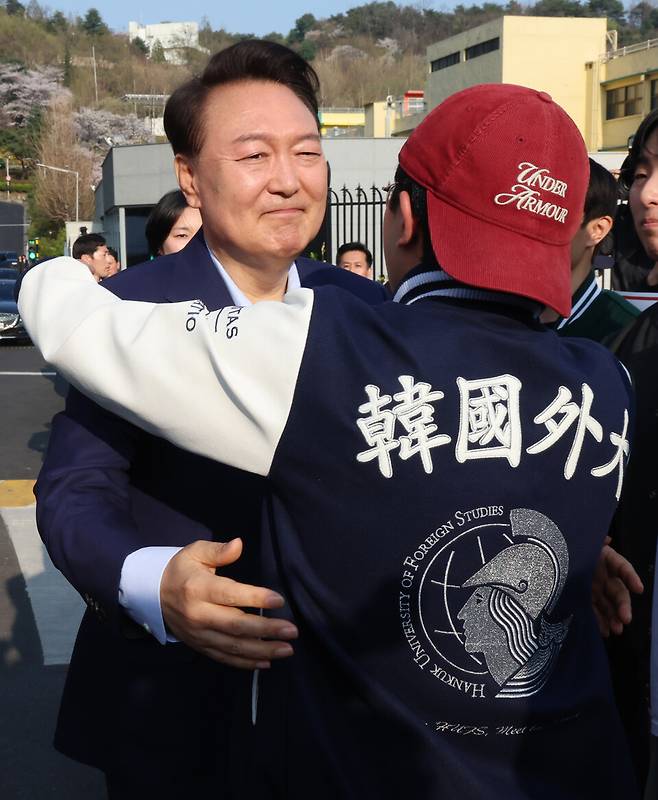 윤석열 전 대통령이 4월11일 오후 서울 용산구 한남동 대통령 관저를 떠나기 전 정문 앞에서 20대 청년 지지자와 포옹을 하고 있다. ⓒ 연합뉴스