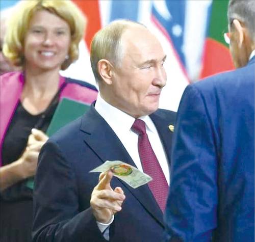 2024년 10월 열린 제16차 브릭스 정상회의에서 푸틴 러시아 대통령이 금 기반 무역통화 ‘브릭스 유닛’ 화폐를 손에 들고 입장하고 있다. (X 캡처)