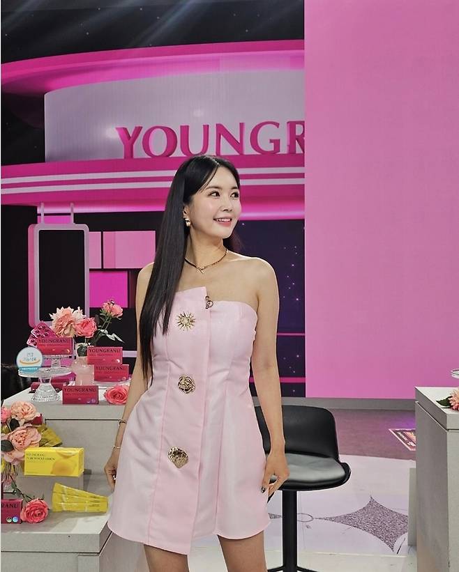 장영란은 핑크톤의 스튜디오 배경과 완벽히 어우러지는 원숄더 핑크 드레스를 입고, 화사한 미소를 뽐내고 있다.사진=장영란 SNS
