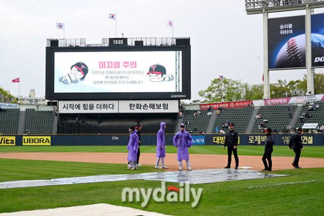 2025년 4월 12일 오후 서울 잠실구장에서 진행된 '2025 신한 SOL뱅크 KBO 리그' 두산 베어스와 LG 트윈스의 경기.경기 시작 30분 전 갑자기 비가 내리기 시작해 방수포를 덮고 있다./잠실=유진형 기자